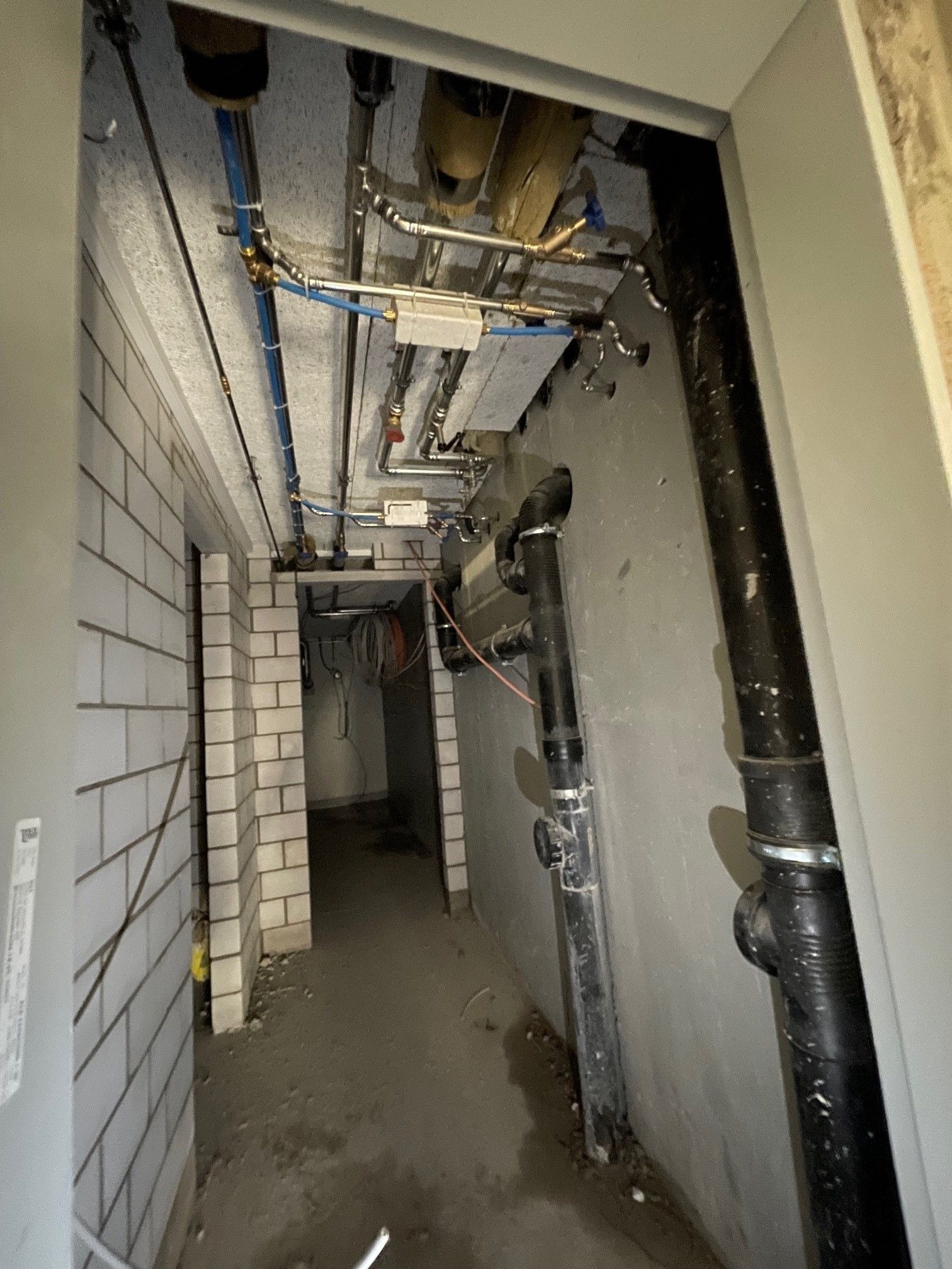 Ein Flur mit Rohren, die von der Decke hängen