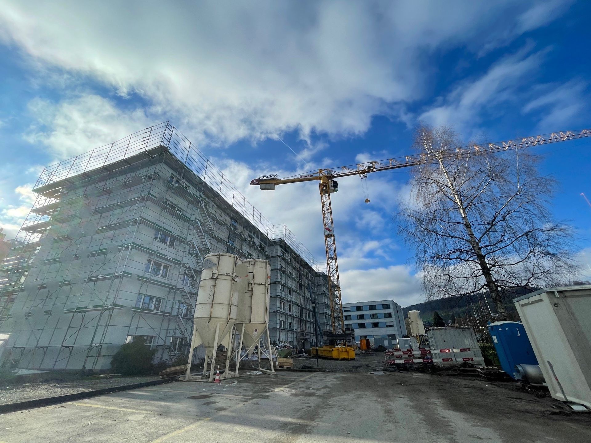 Ein großes im Bau befindliches Gebäude mit einem Kran davor.