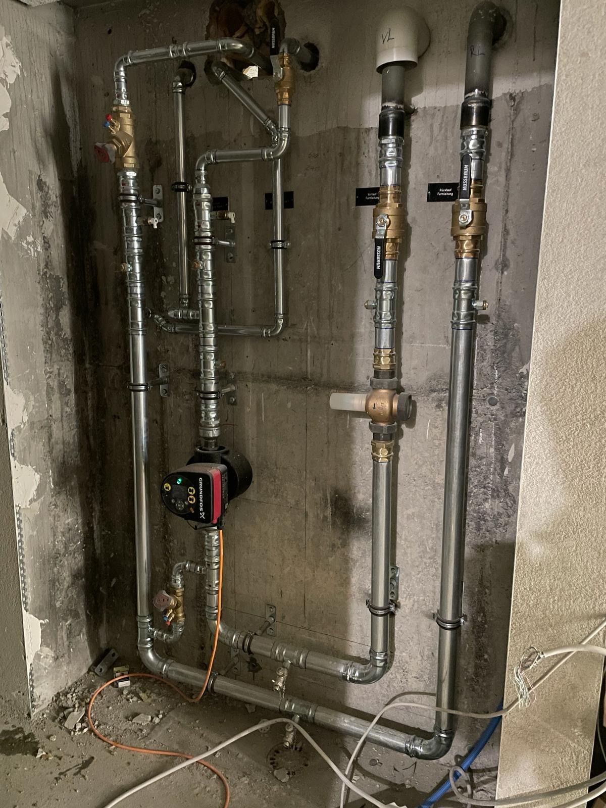 In einem Raum sind mehrere Rohre an einer Wand angeschlossen.