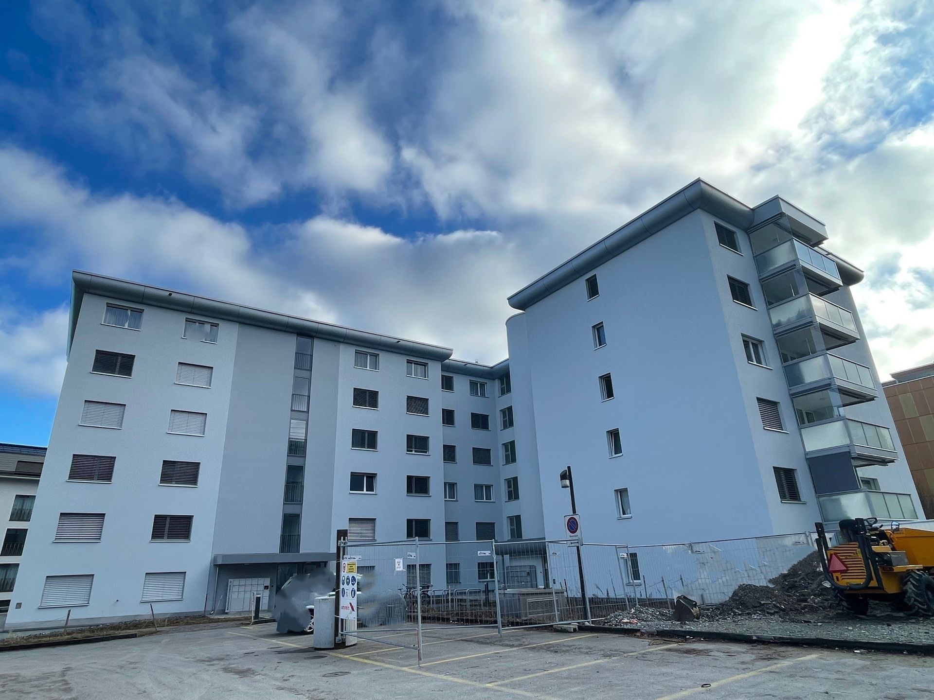 Ein großes weißes Gebäude mit vielen Fenstern wird abgerissen.