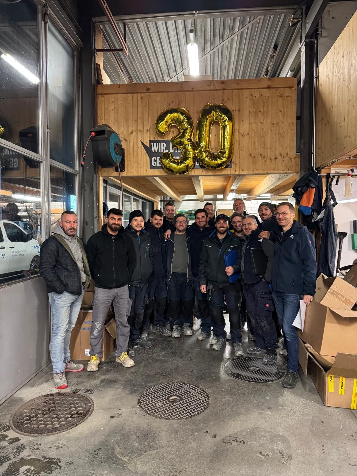Eine Gruppe Männer posiert in einer Garage für ein Foto.
