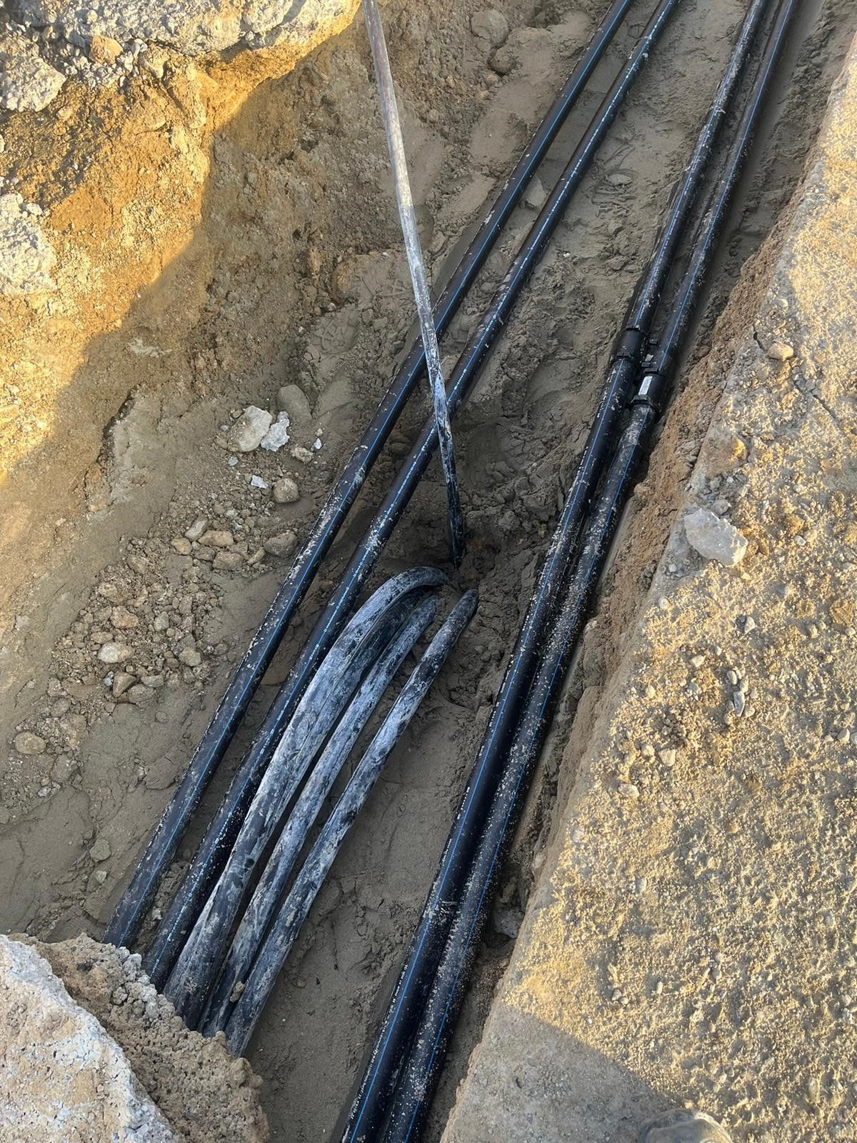 Ein Haufen Stromkabel liegt im Dreck.