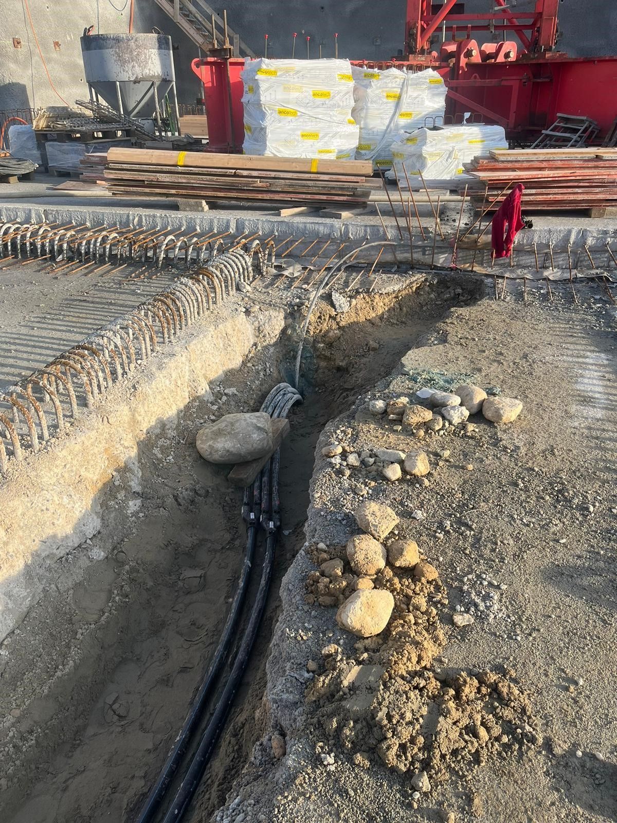 Eine Baustelle mit einem Haufen Rohre im Dreck.