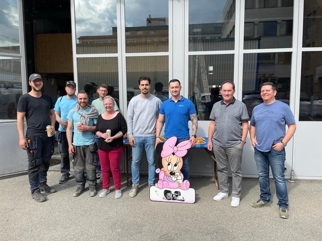 Eine Gruppe von Menschen posiert vor einem Gebäude für ein Foto.