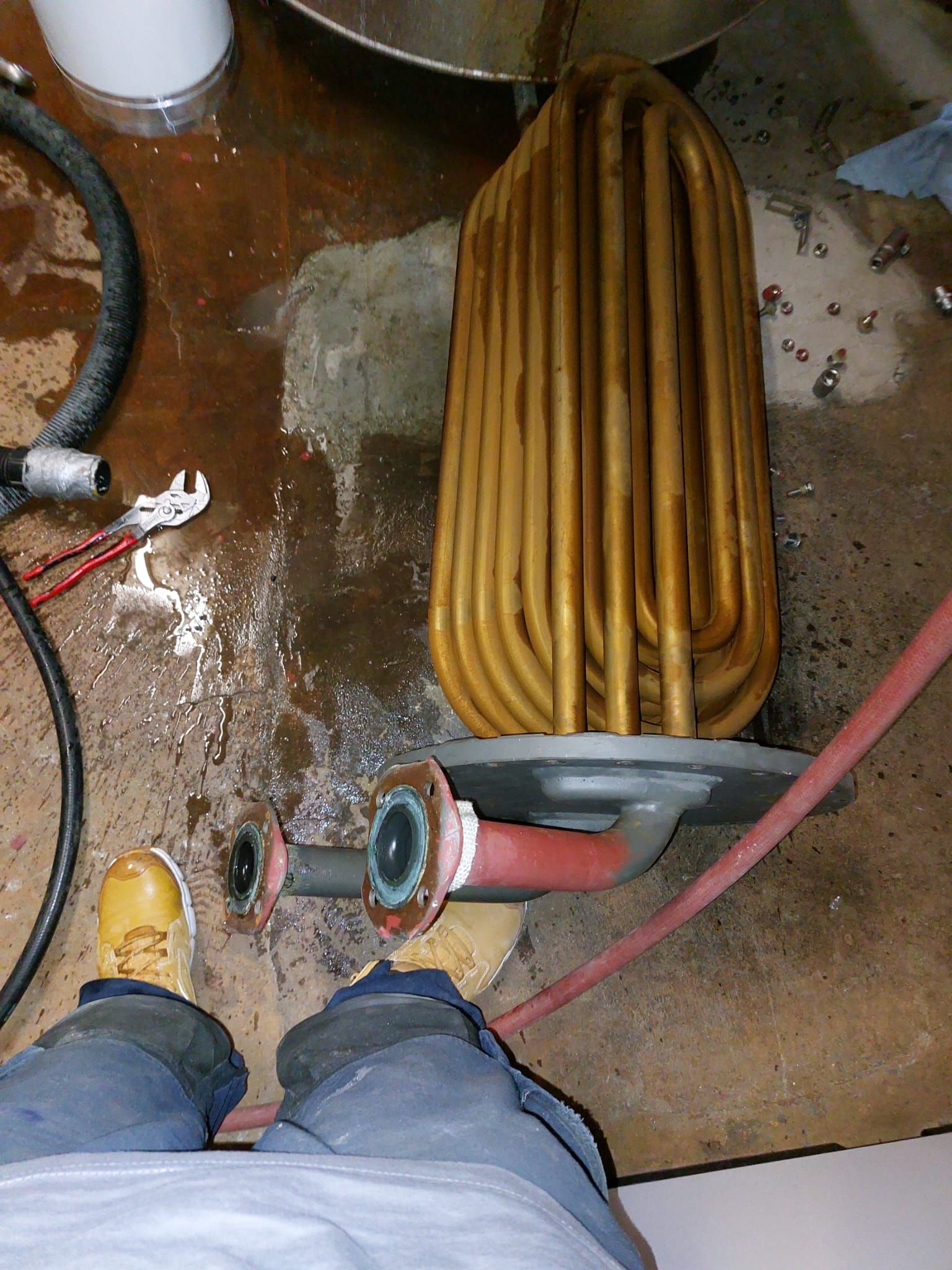 Eine Person steht neben einem rostigen Rohr auf dem Boden