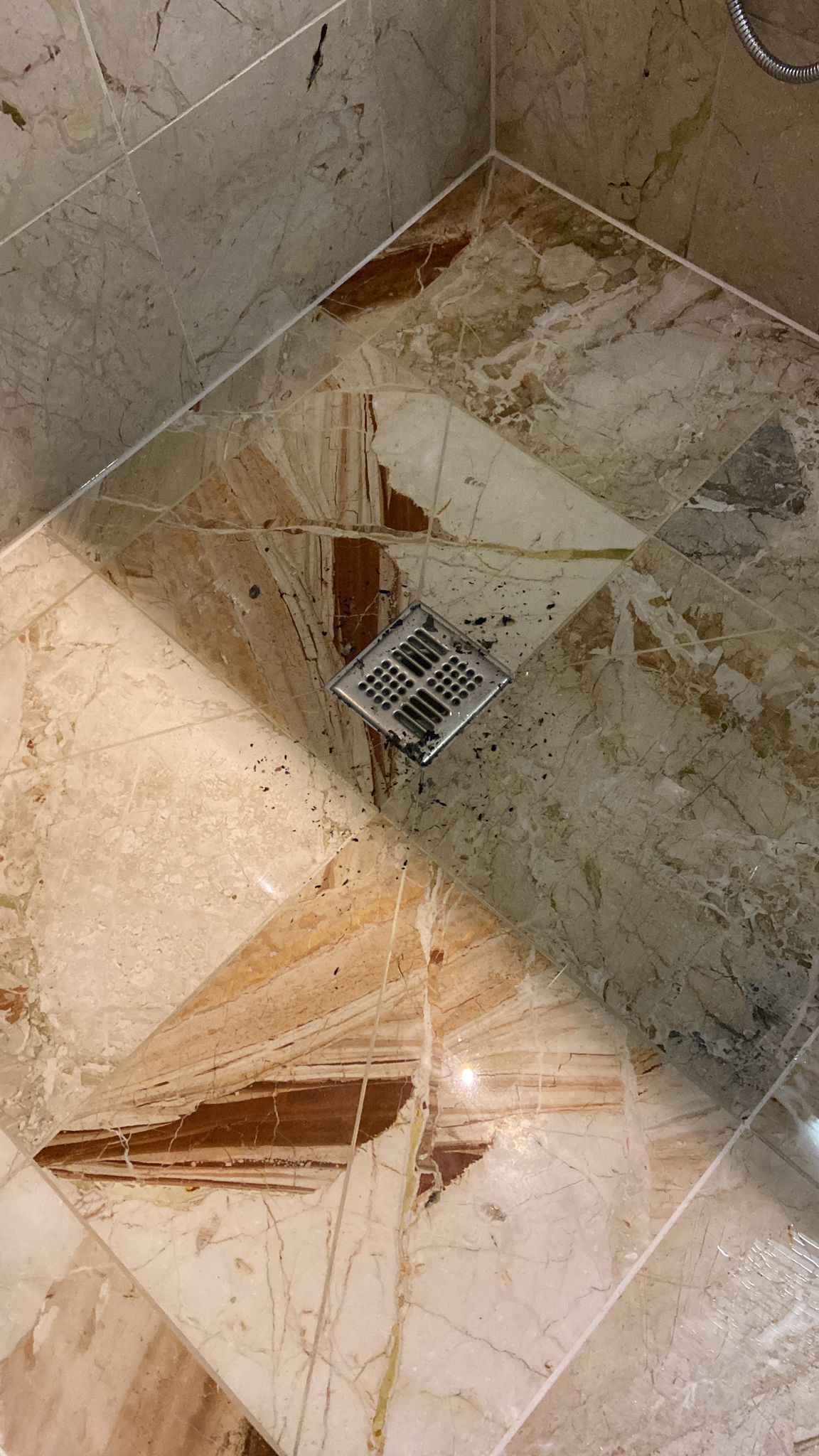 Eine Nahaufnahme eines schmutzigen Duschbodens mit einem Abfluss.