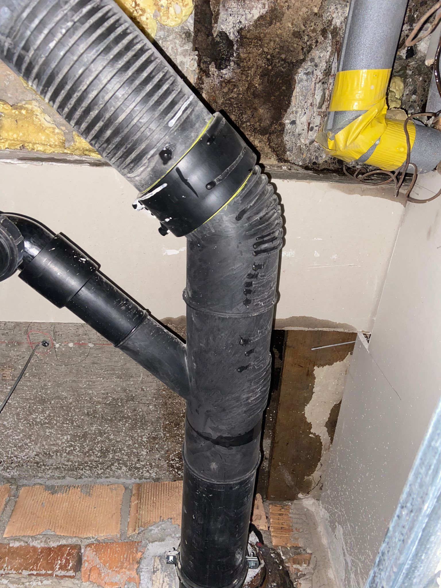 Eine Nahaufnahme eines schwarzen Rohrs, an dem ein gelber Schlauch befestigt ist.