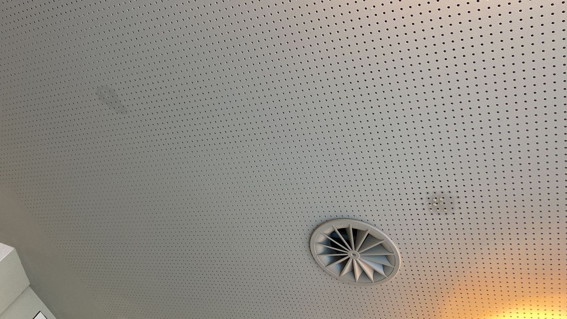 Eine Decke mit Löchern darin und einem Ventilator darauf