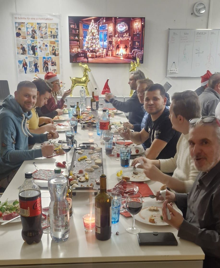 Eine Gruppe von Menschen sitzt an einem langen Tisch und isst Essen