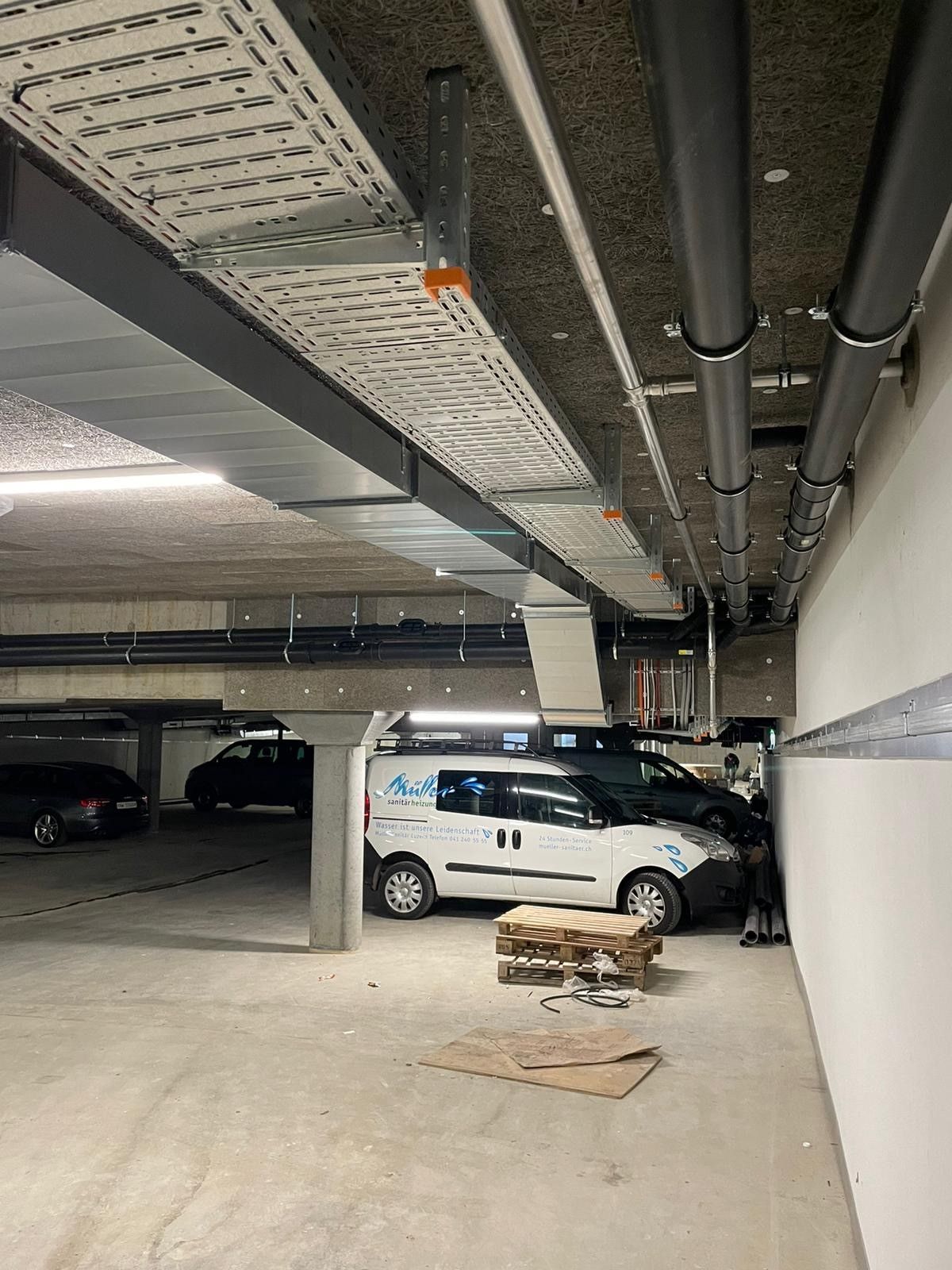 Ein weißer Lieferwagen steht in einem Parkhaus.