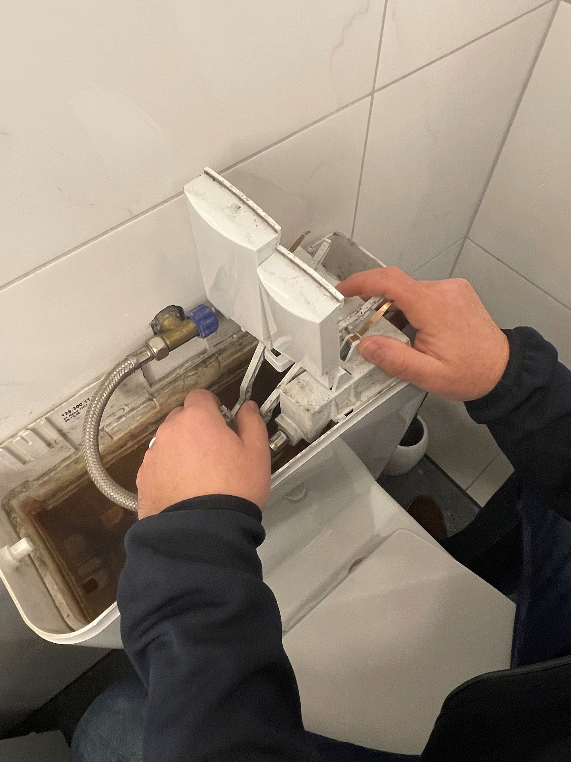 Eine Person repariert eine Toilette in einem Badezimmer