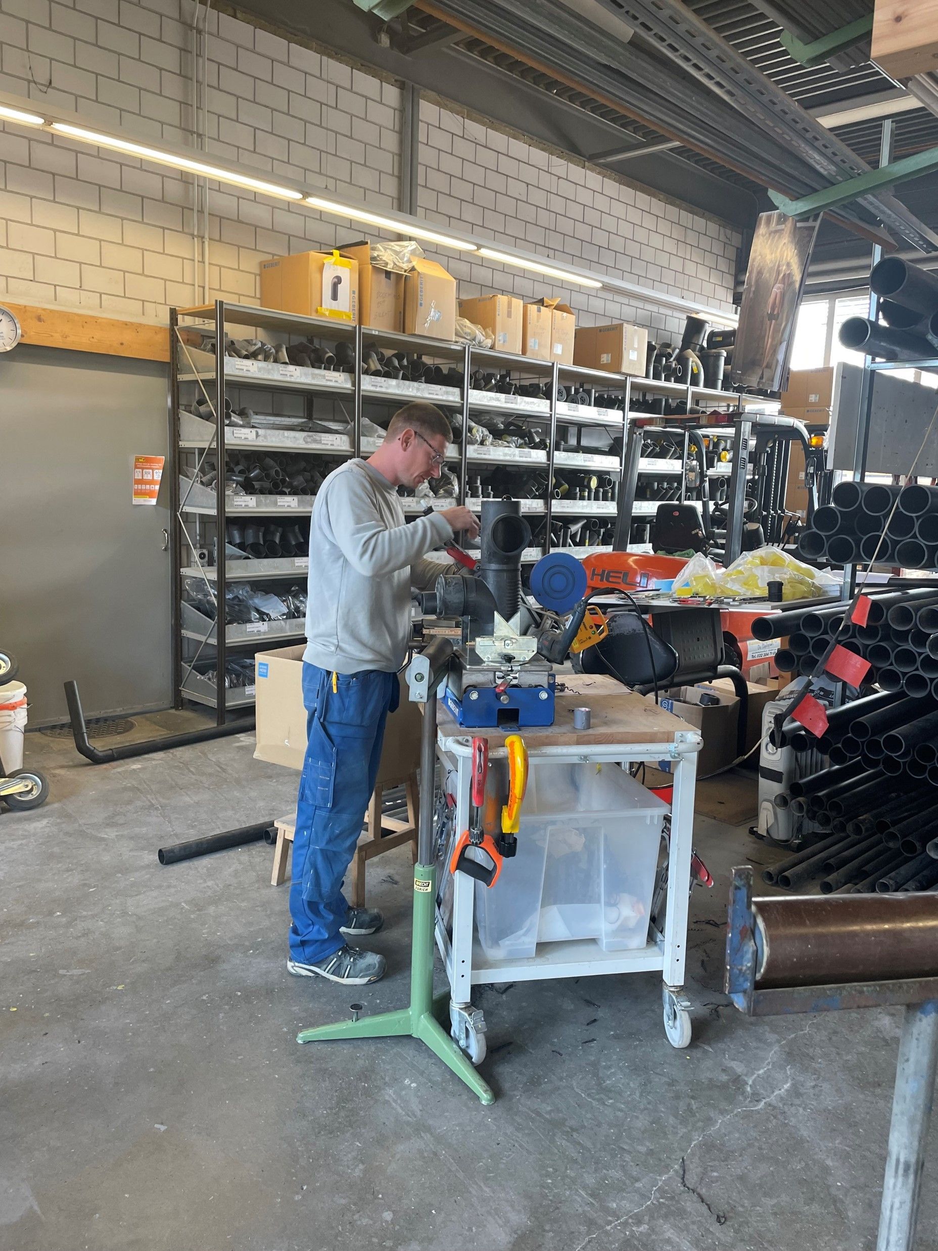 Ein Mann arbeitet in einem Lager an einer Maschine.