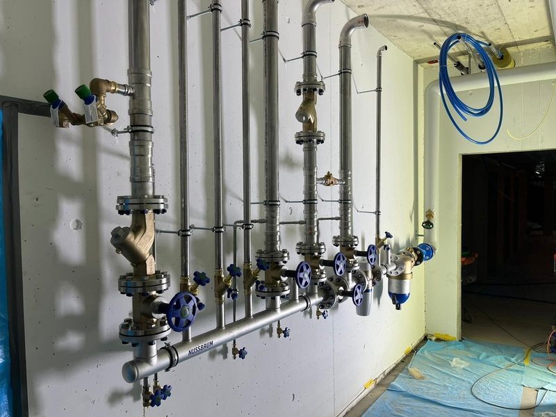 In einem Raum hängen mehrere Rohre an der Wand.