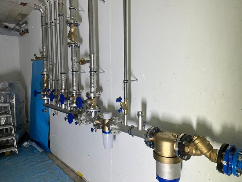Ein Raum mit vielen Rohren und Ventilen an der Wand.