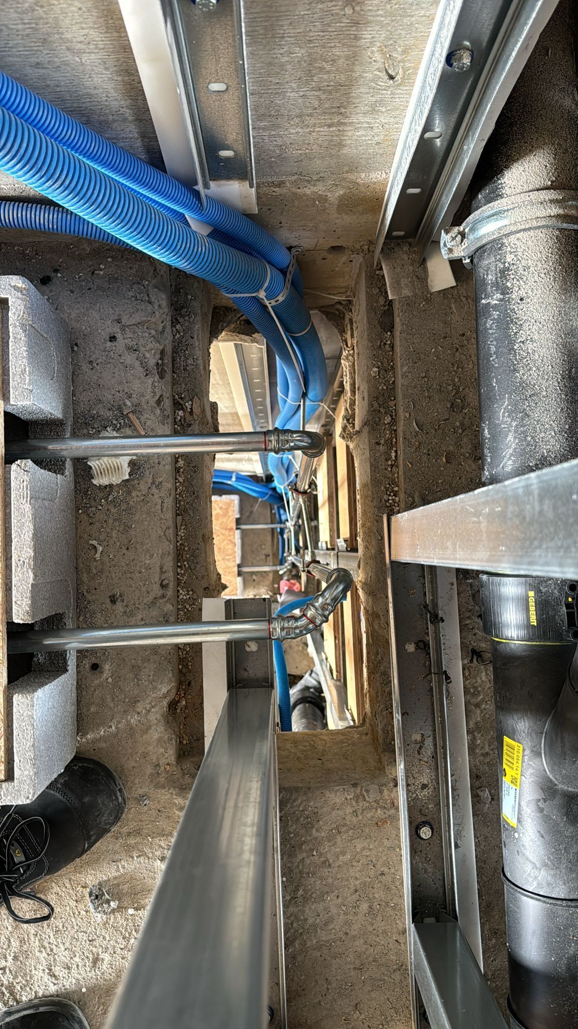 Ein Haufen Rohre hängt von der Decke eines Gebäudes.