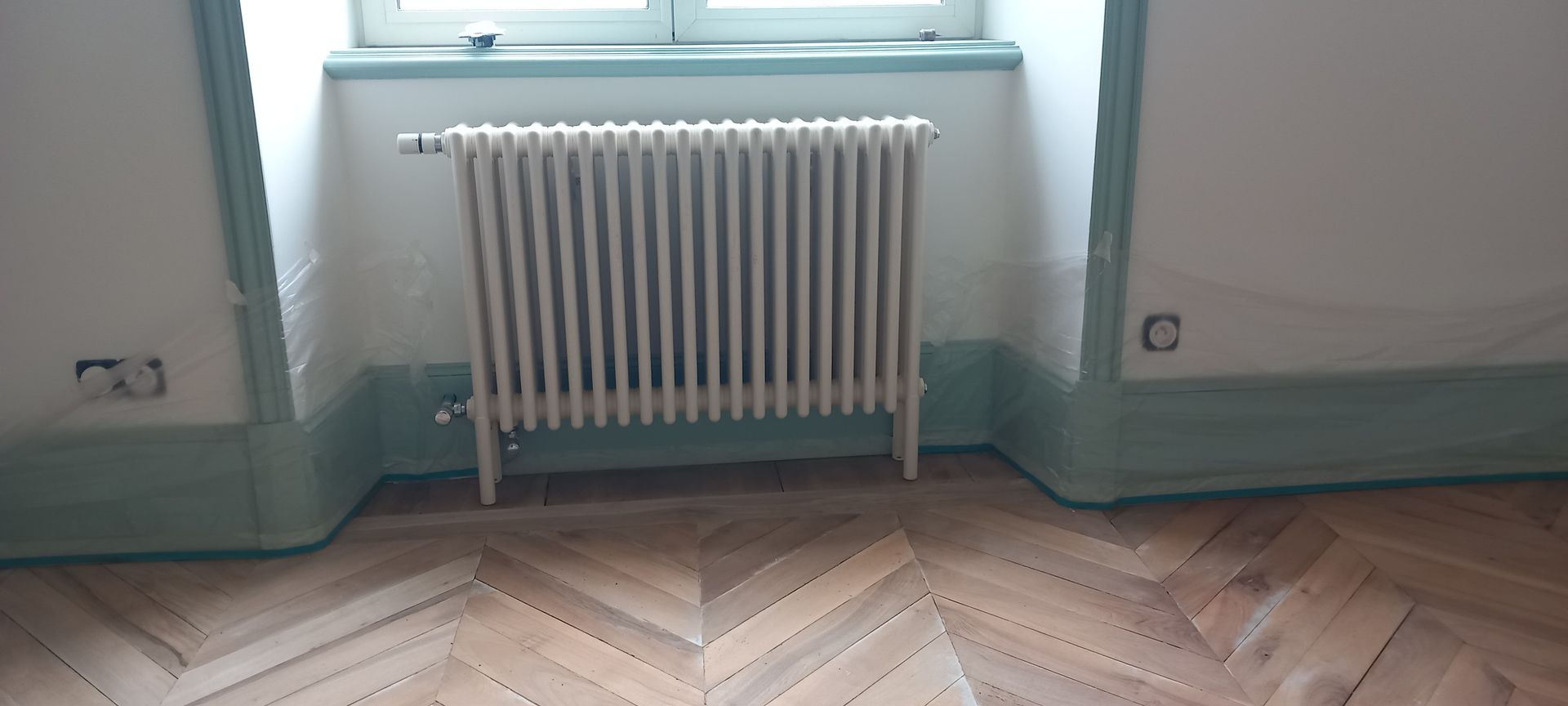 Un radiateur et des plinthes bleues.