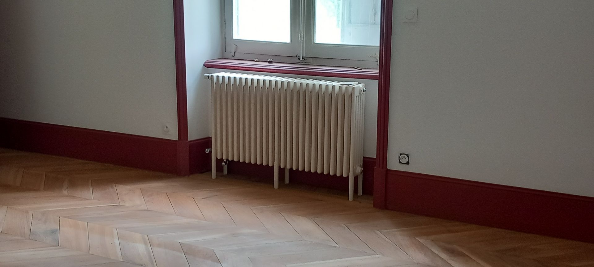 Un radiateur avec des plinthes rouges.