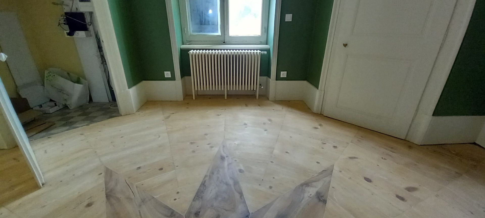 Un radiateur sur un parquet avec une étoile.