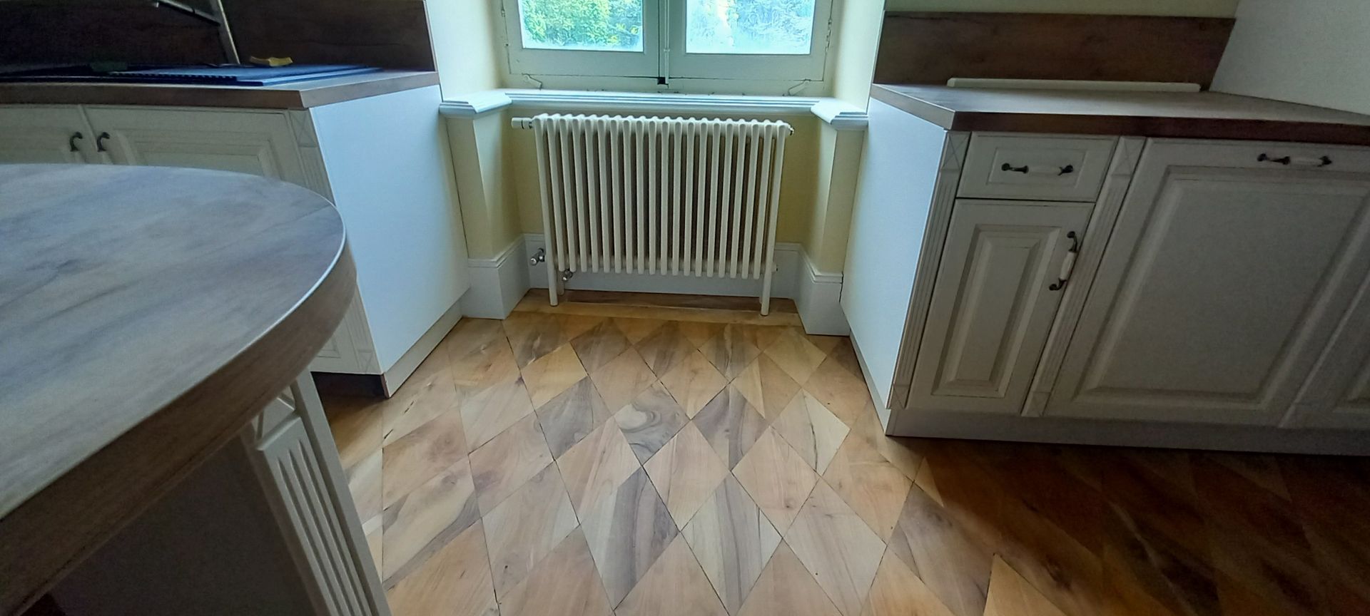 Un radiateur sur un parquet avec des losanges.