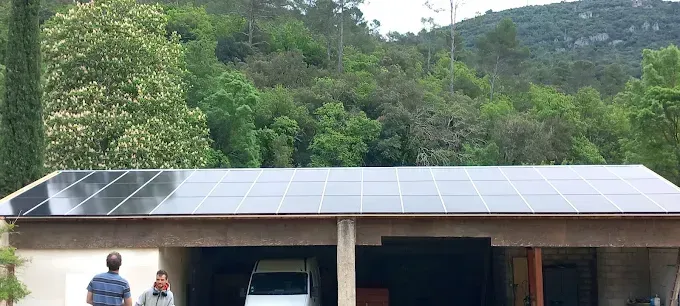 Maison avec panneaux solaires sur le toit dans un cadre verdoyant à flanc de colline