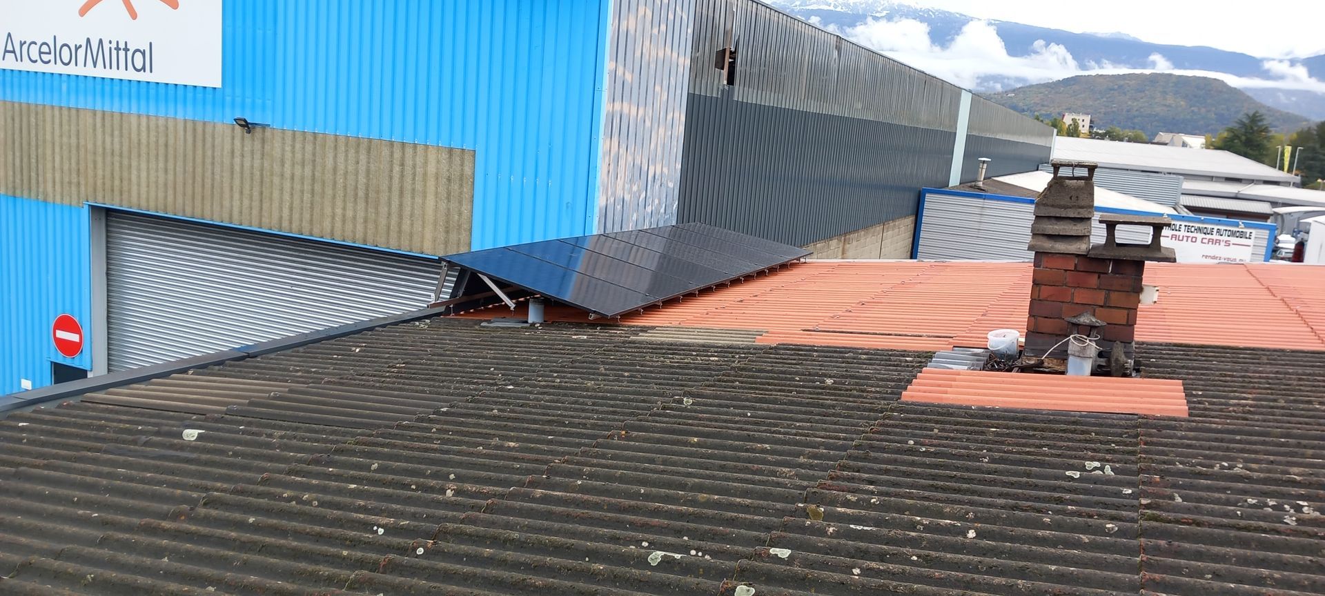 Des panneaux solaires sur un toit noir et orange.