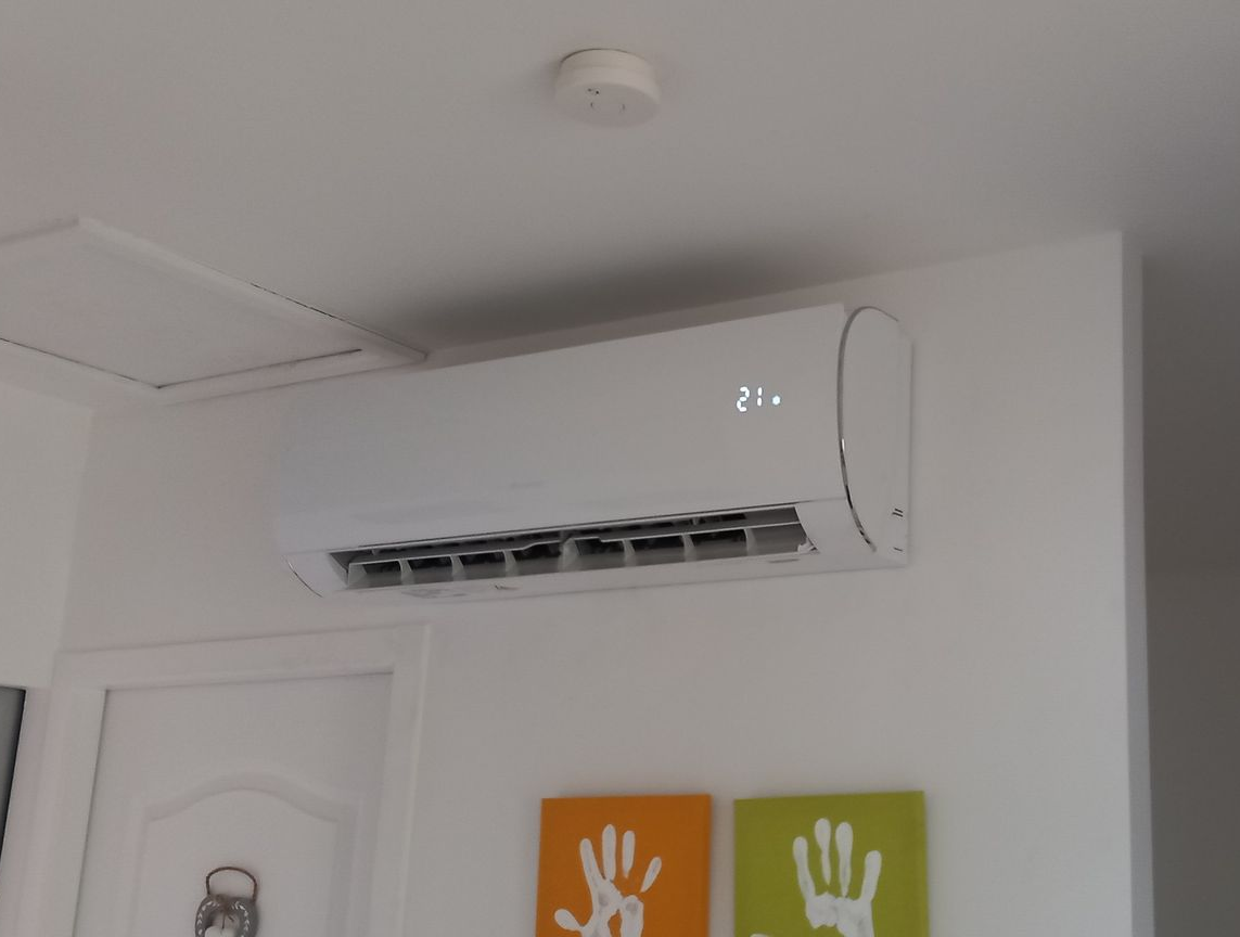 Un climatiseur au-dessus de deux tableaux de mains.