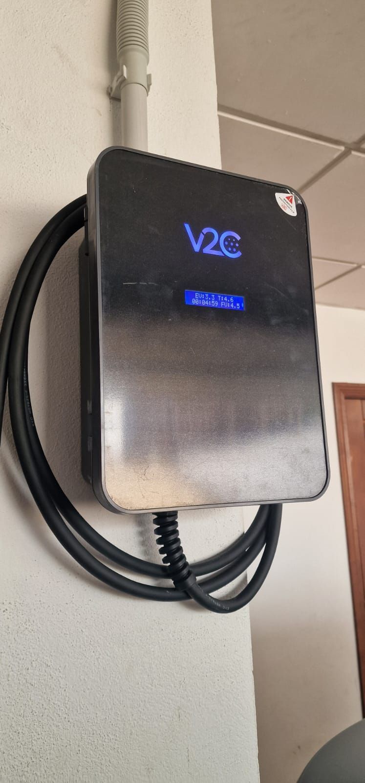Cargador de pared para vehículos eléctricos. Tiene una pantalla que muestra 