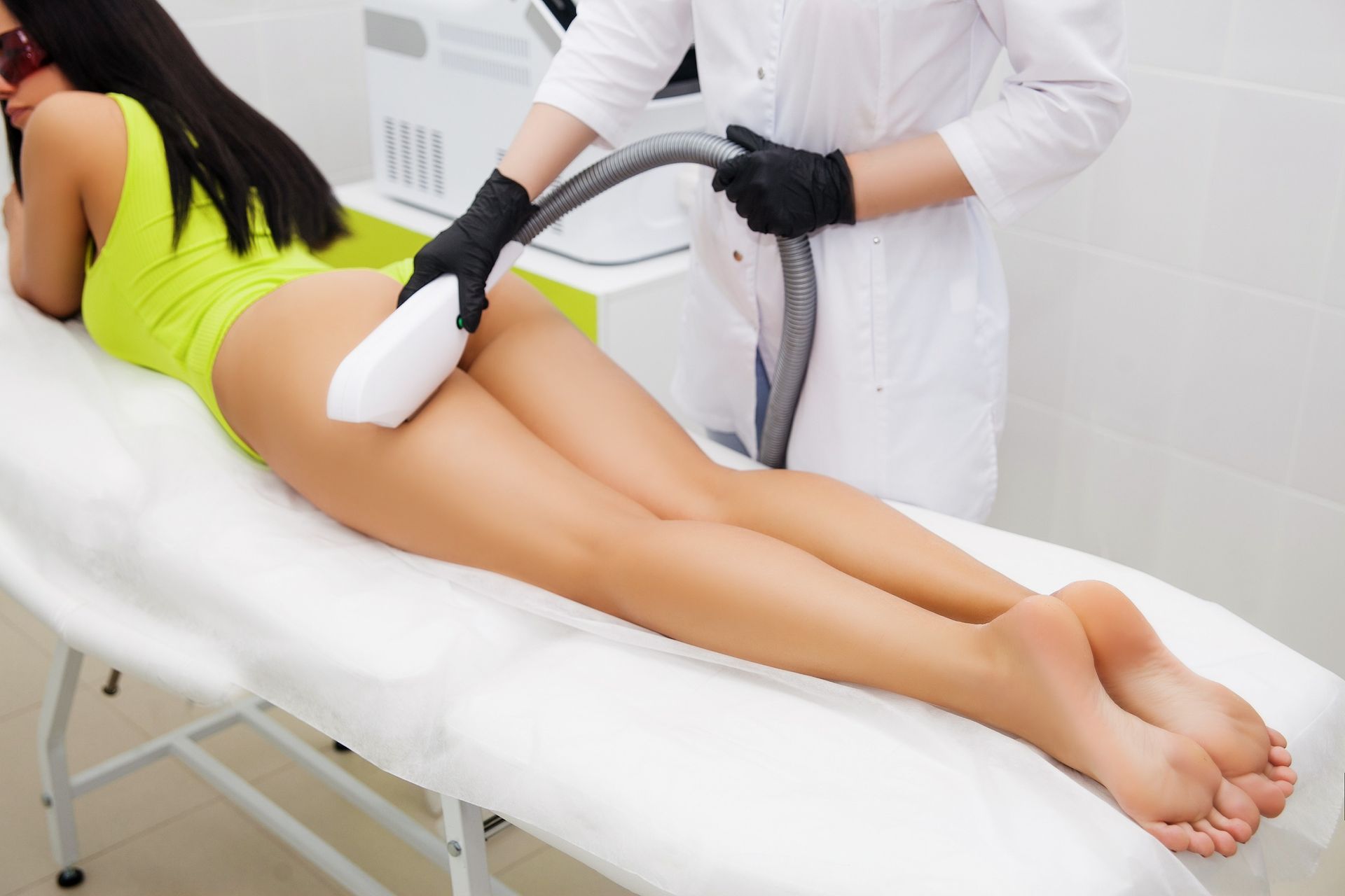 Una mujer está recibiendo un tratamiento de depilación láser en las piernas.