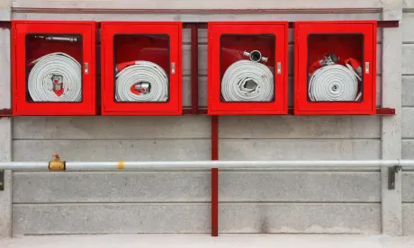 Armario para extintor y manguera contra incendios en una pared.