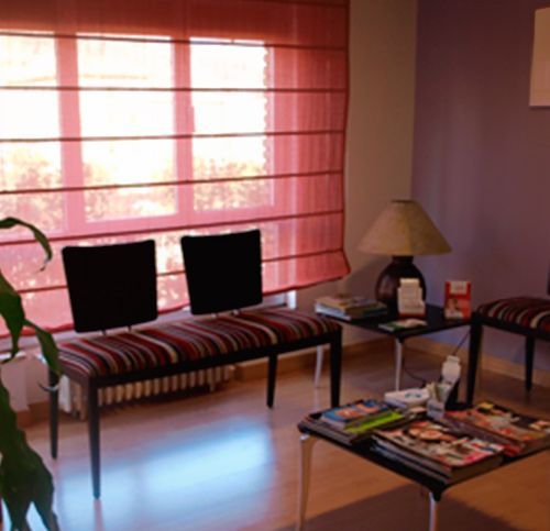 Una sala de espera con sillas, una mesa y una lámpara.