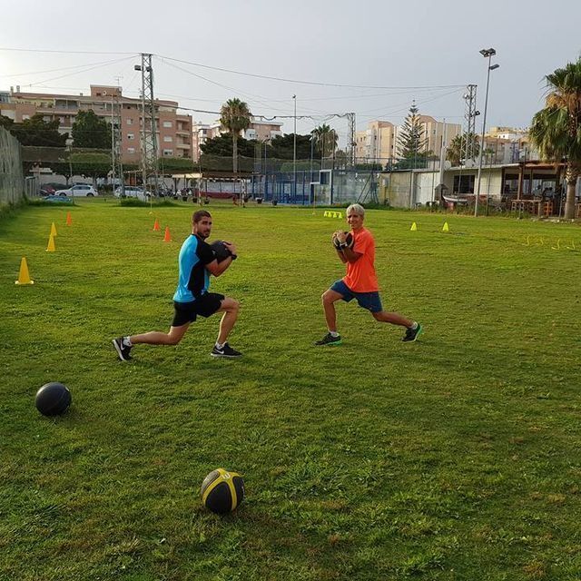Dos hombres están jugando al fútbol en un campo de hierba.