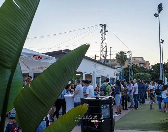 Un grupo de personas se reúne frente a un cartel de Coca Cola.