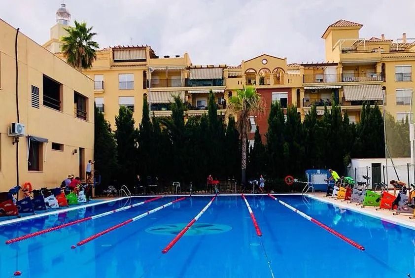 Una gran piscina con un edificio al fondo.