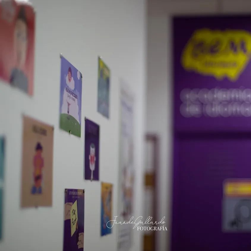 Una fila de carteles en una pared con un cartel morado al fondo.