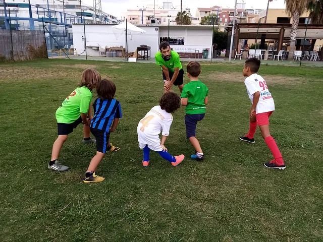 Un grupo de chicos jóvenes están jugando al fútbol en un campo.
