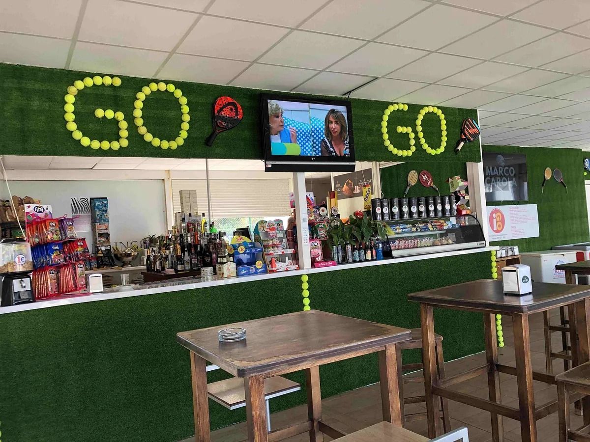 Un restaurante con mesas y un cartel que dice ¡Vamos!