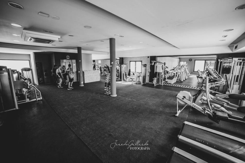 Una fotografía en blanco y negro de un gimnasio con mucho equipamiento.