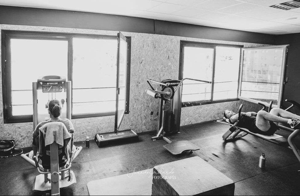 Una fotografía en blanco y negro de personas haciendo ejercicio en un gimnasio.
