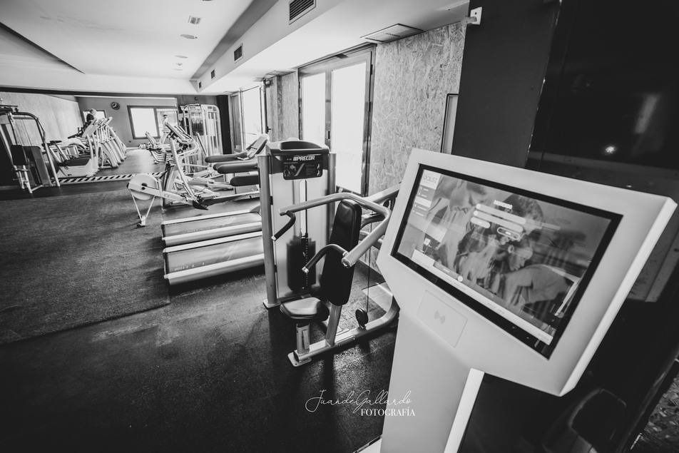 Una fotografía en blanco y negro de un gimnasio con un monitor en primer plano.
