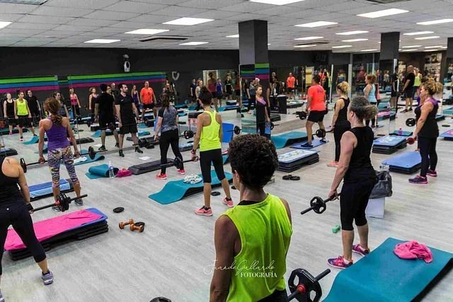 Un grupo de personas está haciendo ejercicios en un gimnasio.