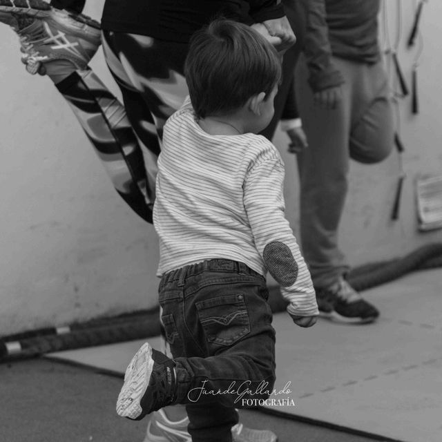 Una fotografía en blanco y negro de un niño pequeño sostenido por una mujer.