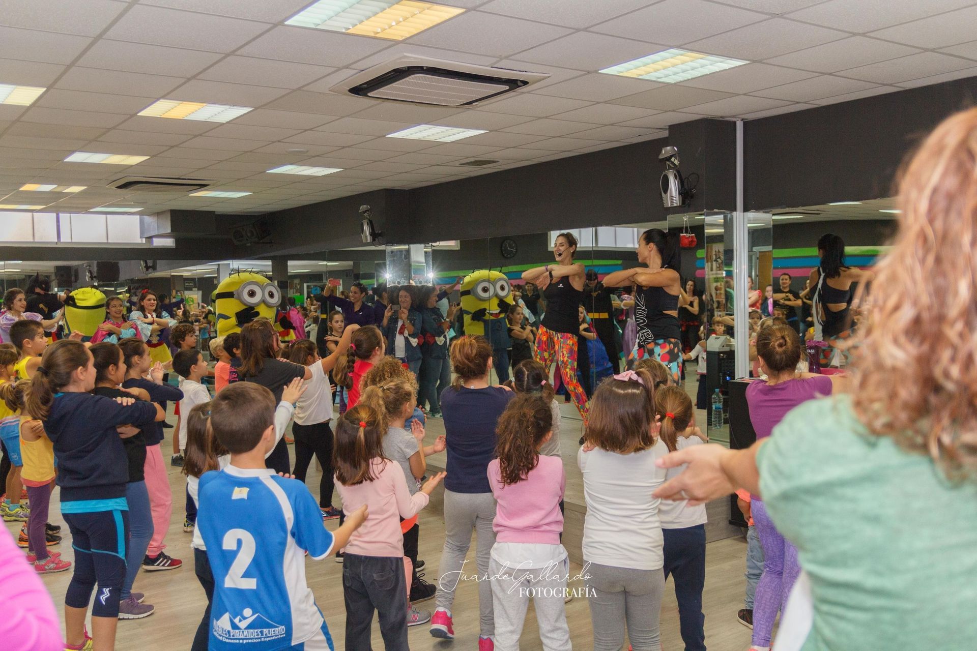 Un grupo de niños está bailando en un gimnasio.
