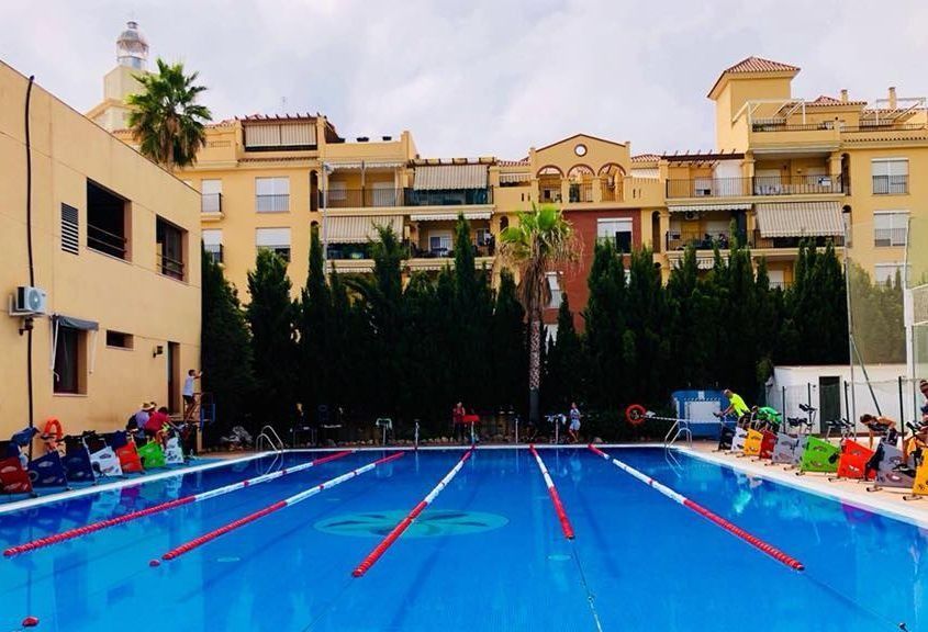 Una gran piscina con un edificio al fondo.