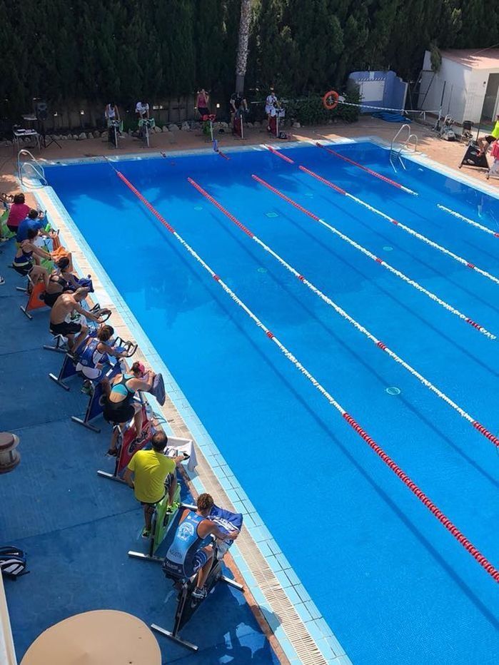 Un grupo de personas está sentado alrededor de una gran piscina.
