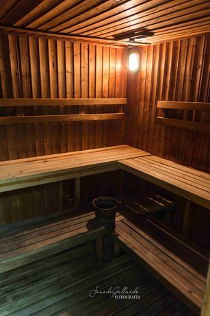 Una sauna de madera con un cubo en el banco y una luz en el techo.
