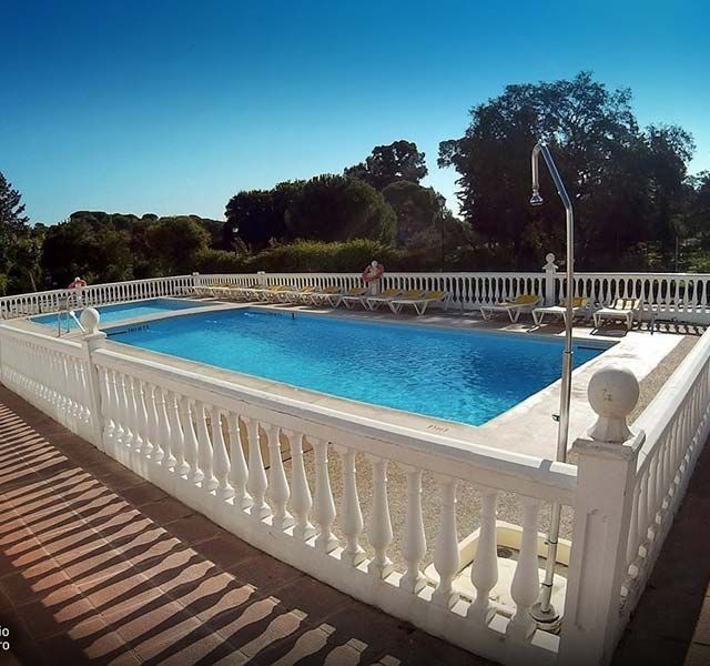 Una gran piscina rodeada por una valla blanca.