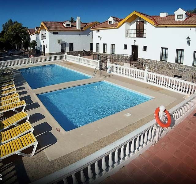 Una gran piscina frente a un edificio blanco.