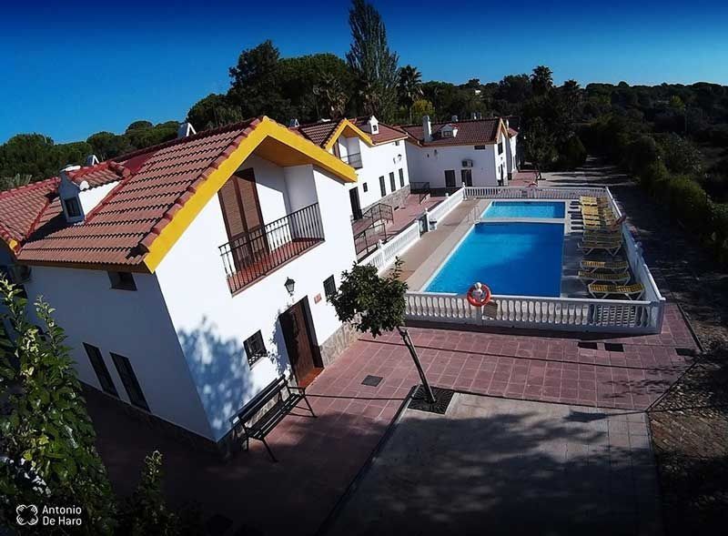 Una vista aérea de una casa con piscina en frente.