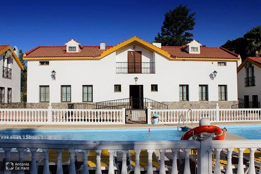 Una gran casa blanca con una piscina delante de ella.