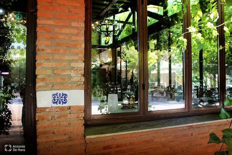 Una pared de ladrillos con un cartel azul y blanco.